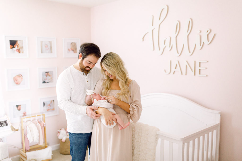 Photo of mother and father holding baby in nursery by Cincinnati maternity photographer