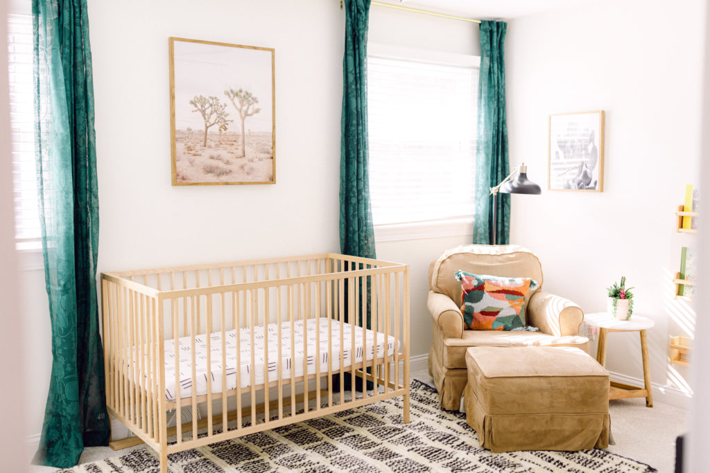 Newborn nursery with natural wood tones, golds, and greens designed by Cincinnati Interior Designer